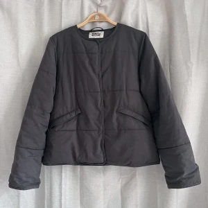 Pufferjacket Weekday - Grå/”smutssvart” pufferjacka från Weekday. Stängs med dolda tryckknappar. Fickor i sidorna. En ganska clean modell som är mycket varm och gosig, perfekt höst- och vinterjacka. I mycket bra skick. Strl S