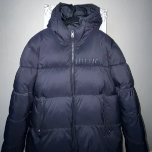 Tommy hilfiger jacka - Tommy hilfiger jacka/puffer till  vintern, den är bra på att hålla värmen när det är kallt, väldigt bra skick. Nypris var ungefär 3200 kr.