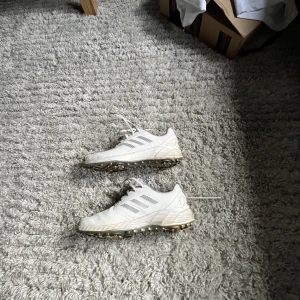 Adidas skor - Vita sköna Adidas skor med dubbar i använt skick  