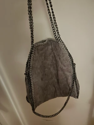 Stella McCartney liknande väska  - Grå Stella McCartney likanande väska, köpt från Amazon. Väldigt fint skick, använd fåtal gånger.