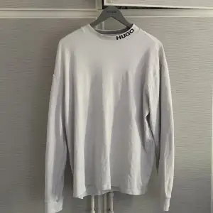 Hugo Boss Tröja/Sweatshirt vit fin med krage, svart text. Köpt på U/M för 1100kr. Nyskick, Storlek L men passa även som M.