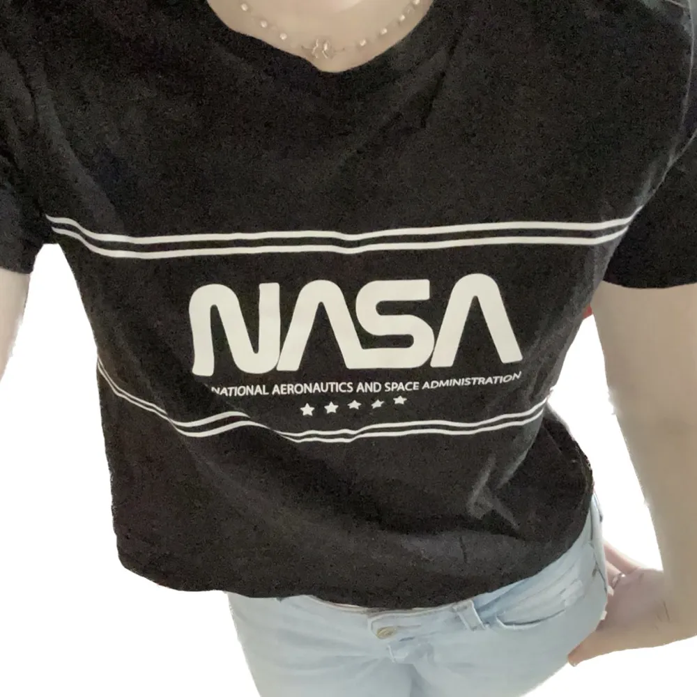 En svart T-shirt med NASA tryck i nyskick, Knappt använd förrutom för att ta dessa bilder då det inte är min stil. Ställ gärna frågor🩵. Toppar.