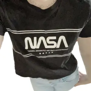 En svart T-shirt med NASA tryck i nyskick, Knappt använd förrutom för att ta dessa bilder då det inte är min stil. Ställ gärna frågor🩵