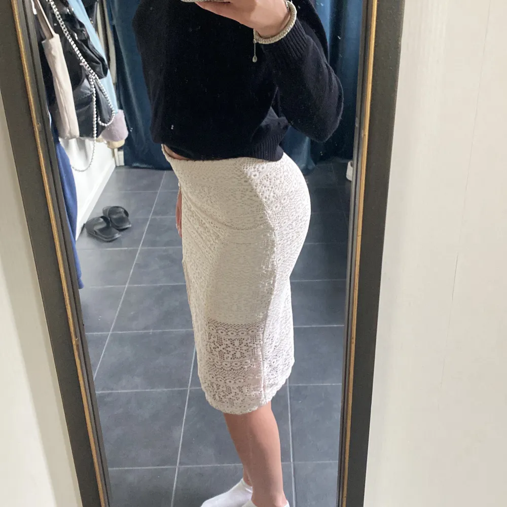 En mönstrad vit tjat kjol med en slits i vänstra benet, går till knäna på mig som är 175💕💕 . Hameet.