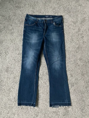 Flared jeans från Lindex - Supersnygga croppade jeans i storlek 42. Lätt utsvängda och i jättefint skick. Säljes pga för små.
