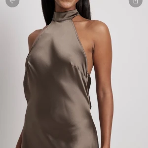 Satin klänning  - Oliv/Brun klänning från nakd, aldrig använd köpte till nyår men tyckte ej den klädde mig.