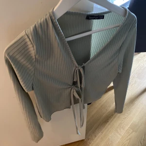 Söt topp  - Mintgröna topp med knuten över bröstet. Den är i storlek 40 men jag tycker den är liten och känns som en S. 