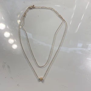 Halsband  - Guld halsband med litet hjärta på