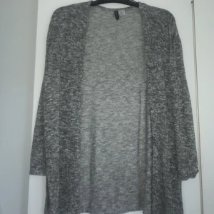 Mjuk kofta - Denna koftan är otroligt mjuk. Den är gråspräcklig i färgen och därmed lätt att matcha till många olika plagg.