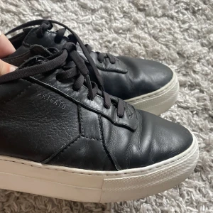 Axel Arigato skor  - Säljer dessa svarta Arigato läderskor i storlek 38. Inga defekter förutom att de är creasade där fram. Använda 2 gånger av mig, men haft en ägare innan mig därav priset. Säljer då de är för små för mig. Vill få sålt så snabbt som möjligt!❤️