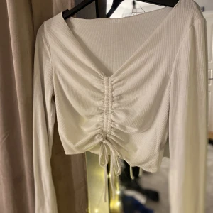 Vit topp - Fin vit topp med detalj i mitten. Säljs då den inte används längre.