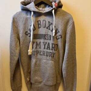 Grå Hoodie SuperDry - En Grå Hoodie från SuperDry. Inte använd så mycket. Är S men passar som M