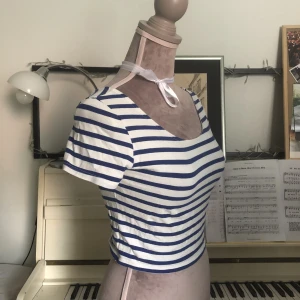 Gullig blå- och vitrandig tröja - Säljer den här fina toppen då den inte kommer till användning för mig. Dockan den sitter på är ca 85cm runt bysten och 65cm runt midjan. Stretchigt material så kulle säga att den är S/M