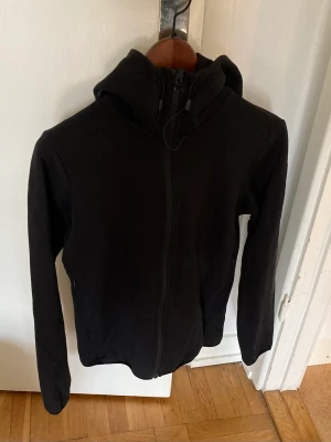 Peak performance huvtröja w tech zip hoodie svart stl s - Jättefin hoodie med dragkedja från Peak Performance. Sparsamt använd. Svart med märket tryckt på höger arm och loggan tryckt på huvan. Stl S. Jätteskön! Mejla för fler bilder.