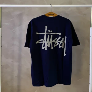 Stussy tröja - En blå stussy tröja med stort tryck på ryggen.  Storlek Large.