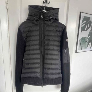 Moncler cardigan  - Säljer nu en Moncler Cardigan i mycket bra skick! Den är såklart äkta, (kvitto finns!) och är i färgen svart. Storlek XL men passar L.