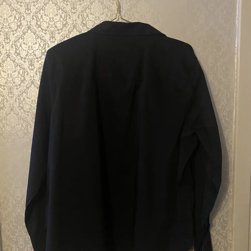 A black brand new shirt in size XL from H&M in Portugal. It has never been used and still have the price tag on. It’s from the women section    Measurements taken laying flat:  Chest: 61cm  Waist: 62cm  Arm: 17cm  Length: 66cm . Skjortor.