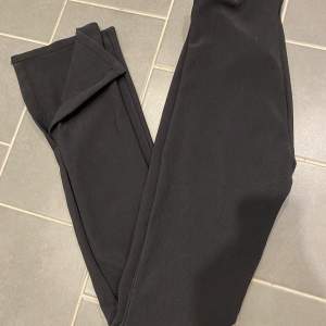 Ribbad svart byxa i stretchigt material med slits! Storlek M