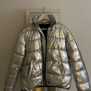 Silver jacka från Diesel - Så cool jacka från Diesel! Perfekt på afterskin⛷️ har klippt bort lappen med storleken men skulle säga en S/M. Defekt vid ena fickan, men går lätt att fixa med lite nål och tråd 💘