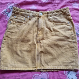 Figurnära jeanskjol - Supersnygg jeanskjol i gul nyans🌻 Köpt på weekday för ett par år sedan men i fint skick. Använd ett par gånger men ligger nu bara i garderoben☺️ Slutar vid mitten av låren på mig ( 162 cm ) storlek 38 men liten i storleken, mer som en 36🩷ingen stretch.