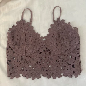 Lila spetstopp - Jättefin lila topp i spets från Nicole Falcianis kollektion från BikBok. Aldrig använd. Storlek L men skulle säga den passar M då den är rätt liten i storlek. Dragkedjan är helt ny då den köptes defekt i butik. 