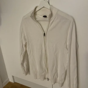 Vit full zip tröja  - Säljer nu min vita full zip tröja från Dan John. Storlek L men tröjan sitter som S-M, säljer pga att den tyvärr inte kommer till användning längre. Nypris ca 450kr, mitt pris 200kr. Hör av dig vid eventuella frågor!