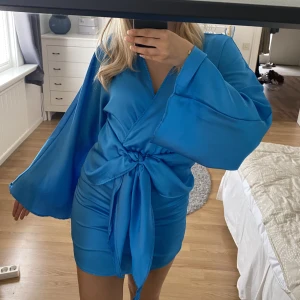 Blå siden klänning  - Säljer min blåa sidenklänning i storlek XS från Gina Tricot med vida ärmar. Endast använd 1 gång som ny. Pris går att diskutera 