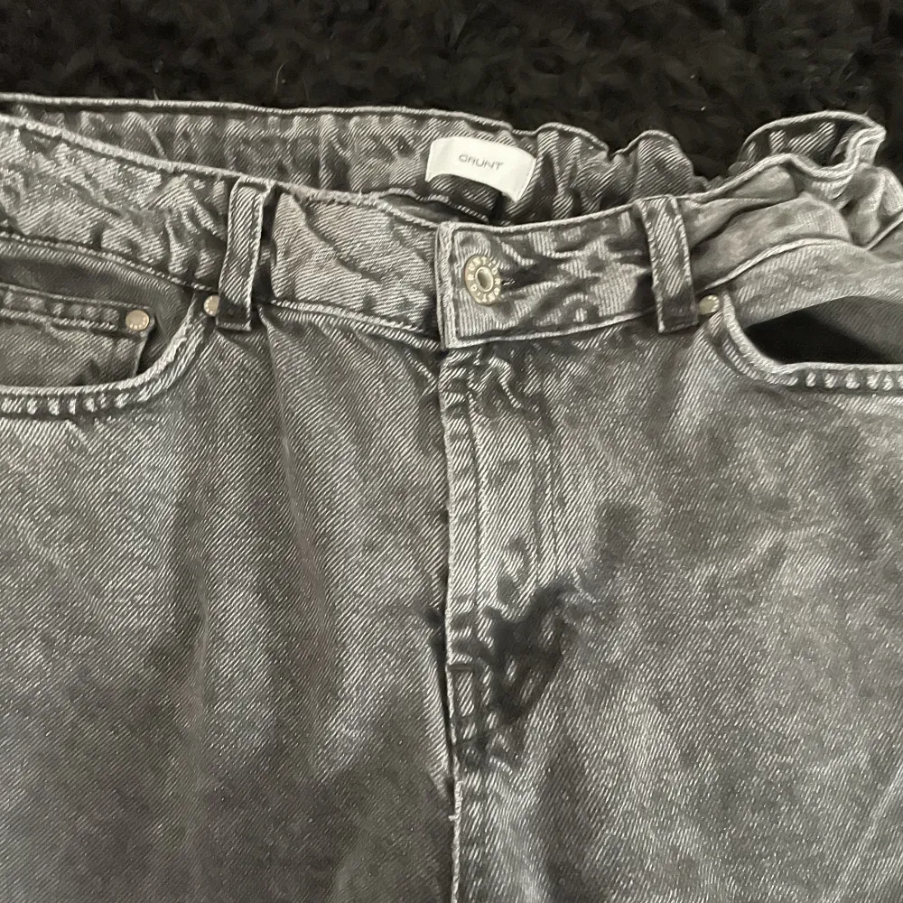 Grunt jeans är i en mörkgrå färg och är i storlek 27. De är 99 cm långa och har en midja på 37 cm. Även om läderbiten på baksidan har en liten defekt, är jeansen i bra skick. Hör av er med frågor . Jeans & Byxor.