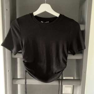Topp från Zara - Svart topp med dragsko på båda sidorna. Använd någon enstaka gång. Köpt på Zara storlek M.
