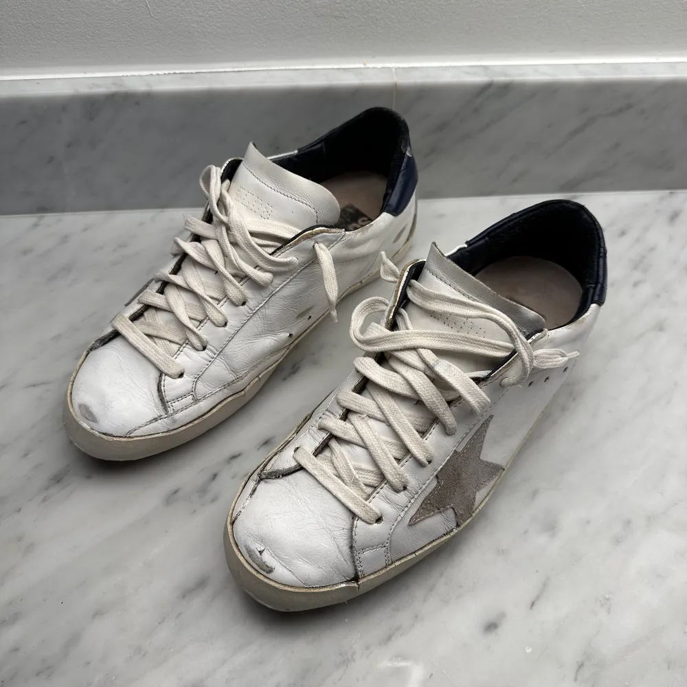Välanvända och reparerade Golden Goose skor i storlek 40. Det har gjorts en touch up färgen och sulan har blivit fixad med ny gummi. Skulle man sula om hos GG så går det på 2000. Skorna är från 2017 och snörena är vita istället för gråa, mycket snyggare! . Skor.