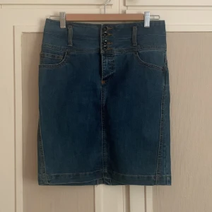 Kort jeanskjol - Säljer denna lite vintage jeanskjolen som aldrig är använd. Säljer då jag städade garderoben och hittade den då, så vill sälja den till någon som kommer använda den mer! Den har fungerande fickor och ett litet slit på baksidan. Ej stretch. Nypris: 349kr