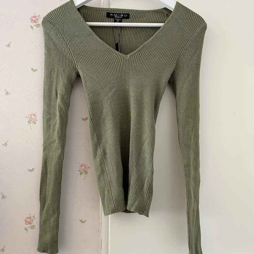 En grön tröja i stretchigt material från NewYorker. Storlek XS, aldrig använd, nyskick🥰 Skriv för mer bilder!💗. Tröjor & Koftor.