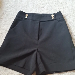 Svarta fin shorts från HM - Fina shorts med gulddetaljer 