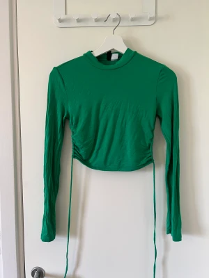 Grön topp från H&M 💚 - Jättefin grön topp från H&M med öppen rygg i storlek S 💚 Säljer för 50kr, köpare står för frakt men kan också mötas upp 💚