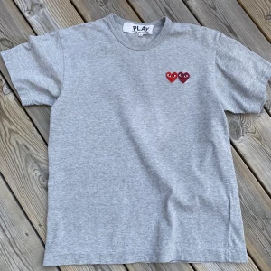 CDG t-shirt - Grå COMME des GARCONS t-shirt, stl.-S Fin t-shirt köpt på NK Göteborg, inga fläckar eller hål. Liten i storlek passar 170/174 (14-16 år)