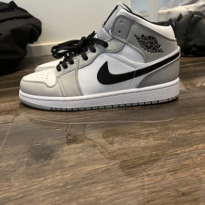 Air Jordan 1 mid light smoke grey/white storlek 43 - Helt nya skor som är helt oanvända. Väljer att sälja skorna eftersom dem var för stora för mina fötter då jag egentligen har storlek 42 men de passade ej mina fötter. Skorna har aldrig varit använda och är lika fräscha som när jag köpte dem. Kartong finns