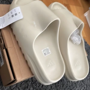 Yeezy slides - Riktigt heta yeezy slides som är helt oanvända med färgen beige. Eftersom slides är helt nya passar de inte bara till 42 utan även ner till. 40 och ifall du har 38 eller 39 passar de ändå.