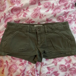 Minishorts från Hollister - Gröna minishorts från Hollister i storlek XS. I bra skick, inte använda på många år. Frakt ingår inte i priset!  Priset är diskuterbart. 