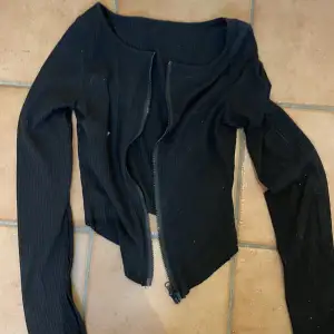 Ribbad svart långärmad tröja med dragkedja