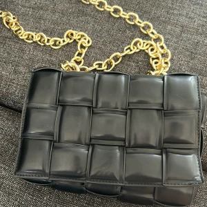 Bottega veneta - En bottega veneta inspirerad väska i svart skinn. Lång + kort guldkedja. 2-fack inuti med ett till fack med dragkedja. Helt ny och oanvänd med plasten kvar på.