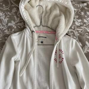 Vit kofta med rosa detaljer och fluffig hoodie. Så mysig men säljs då den ej kmr till användning. Storlek 36❤️ sparsamt använd. 