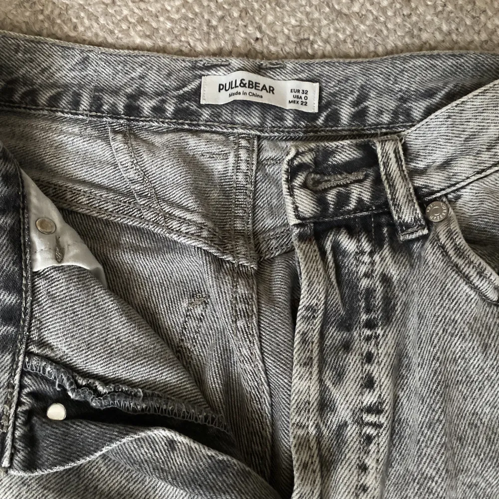 Fina gråa jeans från Pullbear som har använts ca 2 år. Ingert slitage men säljer då det inte riktigt är min stil längre💓vida i benen och i storlek 34💞skriv för fler frågor💞. Jeans & Byxor.