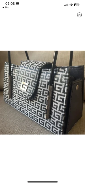 Väska  - En supersöt handväska. Står av sig själv och är stadigt. Rymmer mycket för att vara en liten väska.  Längd: 21cm  Höjd: 12cm  Bred: 10cm