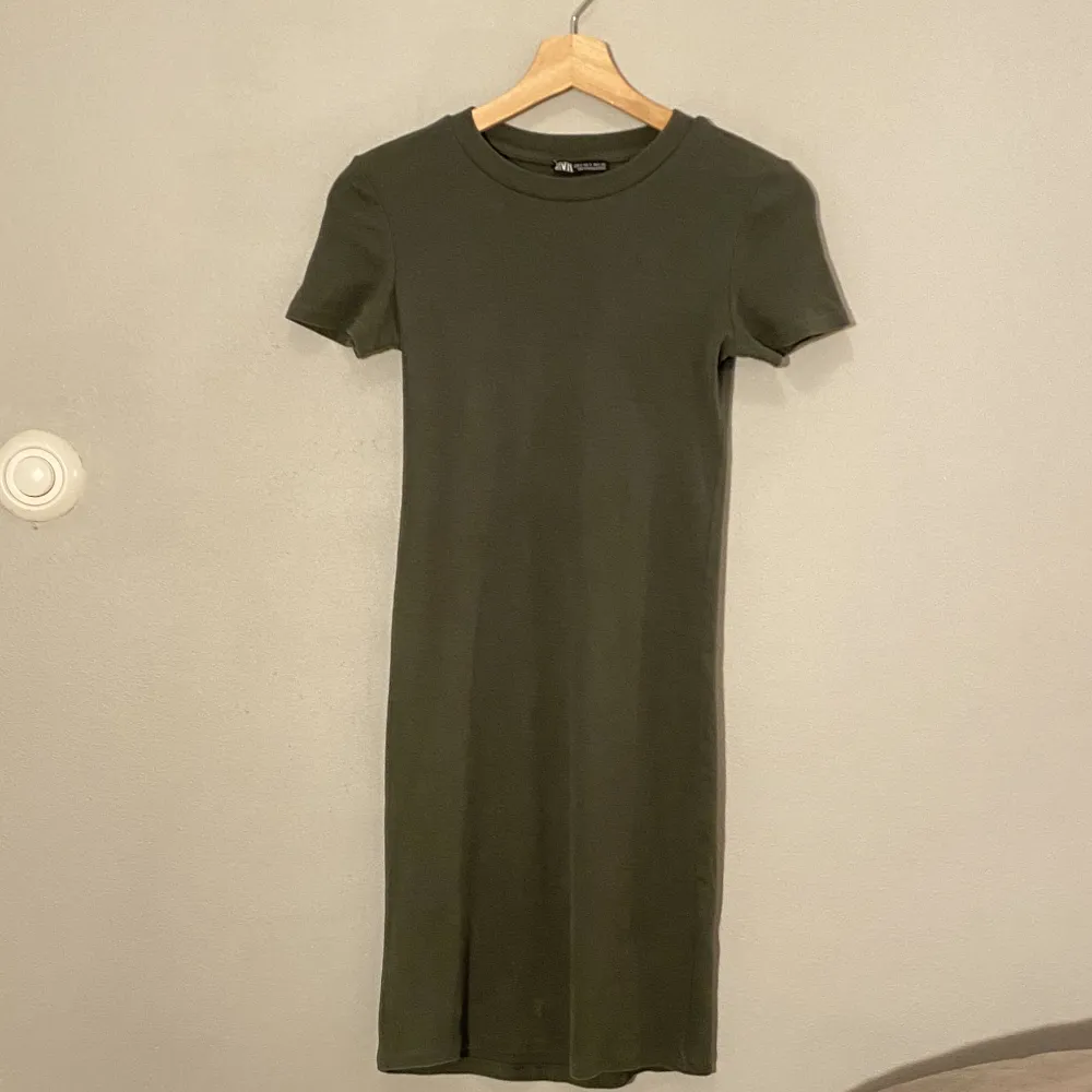 Kort klänning i rubbat material. Säljer även i svart. Klänningen formar sig efter kroppen och är då inte lika rak som den ser ut på bilden. Mekot.