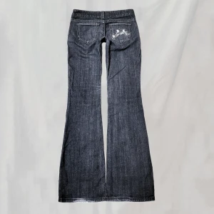 Lågmidjade jeans  - Midja:73,5 innerben:81 Lågmidjade jeans vintage från Guess. Lite gråblå i färgen. Storlek 24, uppskattar passa ca en XS. Lite smått nötta, se bilder för exempel. Nötningar bakre fotändar. Endast några enstaka stenar saknas, överlag bra skick!!🤍