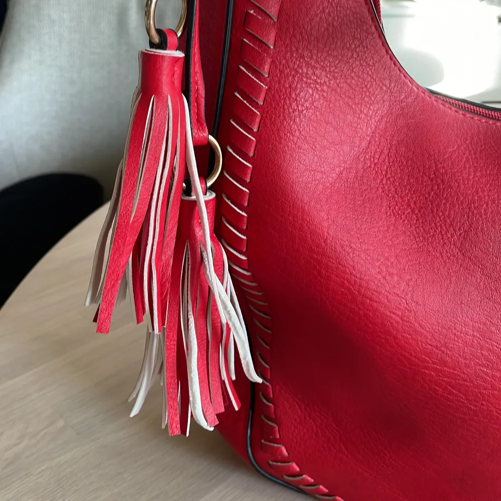 Snygg röd handväska som ny med snygga detaljer och fin form. Köpt i Spanien. Väskor.
