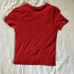 Säljer en söt röd t-shirts. Den är ganska tajt och har ett mönster i tyget. 