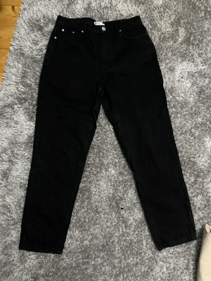 Svarta jeans - Säljer mina svarta mom jeans från Gina Tricot i storlek 40. Endast använda ett fåtal gånger, köparen står för frakten 