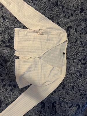 Långarmad tröja - Vit långarmad tröja med två knappar på framsidan. Väldigt skönt matrial som inte blir för varmt under våren/sommaren 