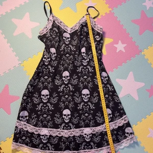 Svart vit emo klänning med skelett huvud - Säljer för att det ej är min stil längre. Hely fläck fri och är ej sönder. Har smvönts en gång för att testa ha på mig den. Längd: 76cm, midjemått: 72cm. Klicka på köp om du vill köpa, kontakta om du har frågor. 